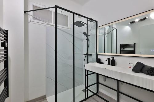 ein Bad mit einer Dusche, einem Waschbecken und einem Spiegel in der Unterkunft Villa avec vue mer panoramique in Carqueiranne