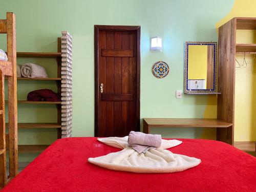 1 dormitorio con 1 cama con manta roja en Barra Quintal - Studio 1, en Barra Grande