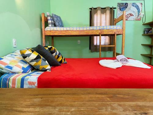 a bedroom with two bunk beds and a red bed at Barra Quintal - Studio 1 in Barra Grande