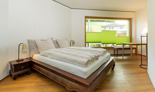 a bedroom with a bed and a table and a window at Kronenwiese in Mosnang