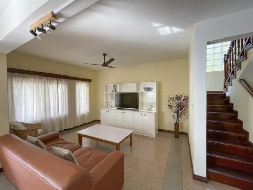 a living room with a couch and a television at Ocean View Villa - Beauvallon villas in Beau Vallon