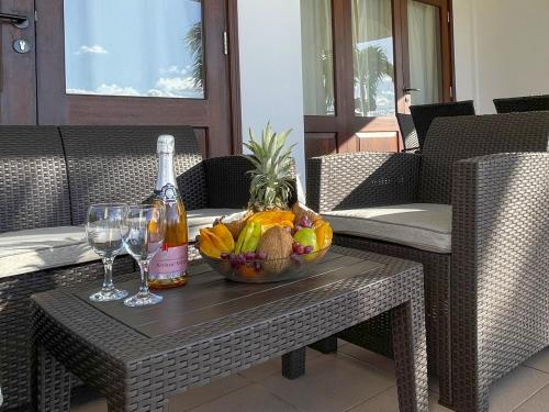 a bowl of fruit and a bottle of wine on a table at Ocean View Villa - Beauvallon villas in Beau Vallon