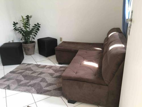 a living room with a brown leather couch and speakers at Apartamento Aconchegante 2 quartos in Vitória da Conquista