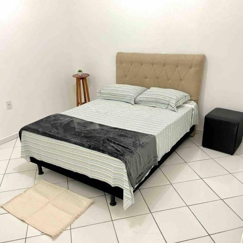 a bedroom with a large bed with a black blanket at Apartamento Aconchegante 2 quartos in Vitória da Conquista