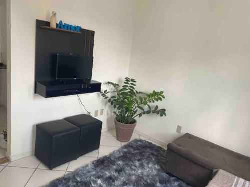 a living room with a couch and a flat screen tv at Apartamento Aconchegante 2 quartos in Vitória da Conquista