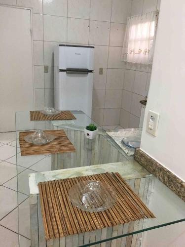 a kitchen with a glass counter with a refrigerator at Apartamento Aconchegante 2 quartos in Vitória da Conquista