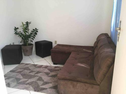 Sala de estar con sofá marrón y 2 altavoces en Apartamento Aconchegante 2 quartos en Vitória da Conquista