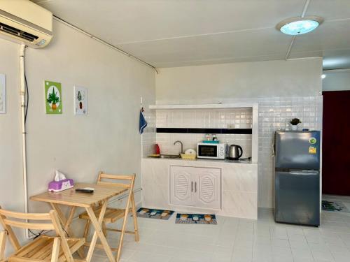 Thung Si KanにあるRoom For rent poppular condo T8 Fl 6のキッチン(冷蔵庫、テーブル、椅子付)
