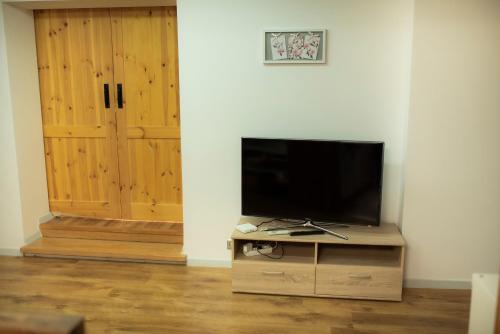 a flat screen tv sitting on a wooden stand next to a door at Apartament 33 Skawina in Skawina