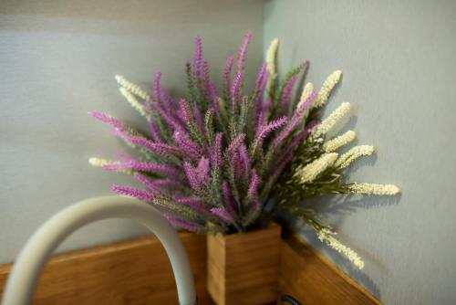 a purple plant in a wooden basket next to a wall at Apartament 33 Skawina in Skawina