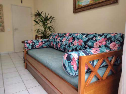 un canapé installé dans un salon orné de motifs floraux dans l'établissement Apto 105 - Edifício Imola - Conforto e Segurança para sua família, à Ubatuba