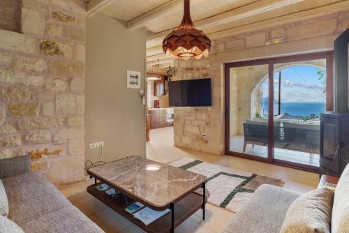 un soggiorno con divano e tavolo di Villa Thalia St George Retreat BY APOKORONAS-VILLAS a Kókkinon Khoríon