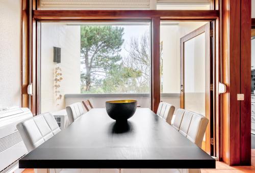 a dining room with a black table and white chairs at Torralta in Carvalhal