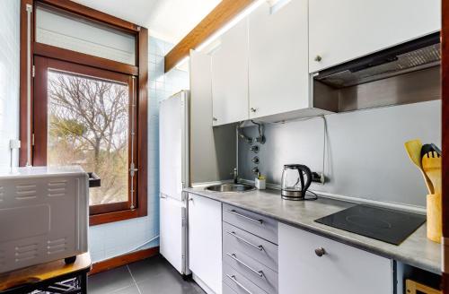a kitchen with white cabinets and a window at Torralta in Carvalhal