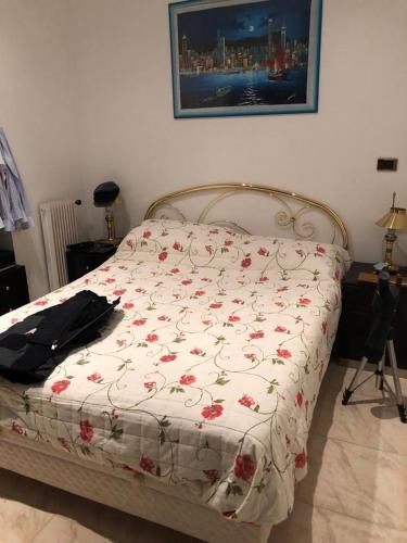 une chambre avec un lit avec une couette fleurie dans l'établissement Boulevarde de la Turbie Beausoleil, à Beausoleil