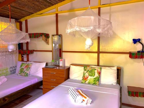 a bedroom with two beds and a dresser at Le Petit Paradis in Roseau