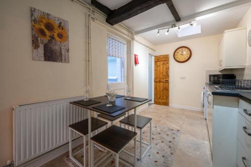 a kitchen with a table and chairs in a room at Town Centre Cottage 3 Bedroom inc Parking (1 car) in Shrewsbury