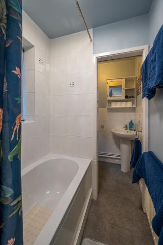 a white bathroom with a tub and a sink at Town Centre Cottage 3 Bedroom inc Parking (1 car) in Shrewsbury