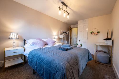 a bedroom with a large bed with a blue blanket at Town Centre Cottage 3 Bedroom inc Parking (1 car) in Shrewsbury