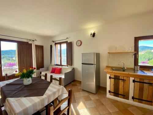 a kitchen with a table and a refrigerator and a sink at Residence La Rosa in Porto San Paolo