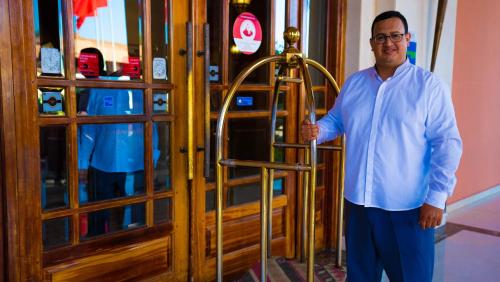 a man holding a ladder in front of a door at Palm Plaza Marrakech in Marrakech