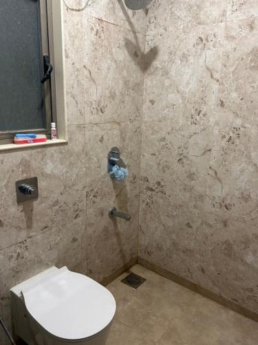 a bathroom with a toilet and a shower at Room in Flat with Amazing City and Sea View in Mumbai