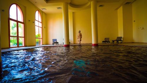 a woman standing in front of a swimming pool at Palm Plaza Marrakech in Marrakech