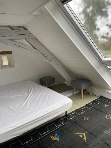 - un lit et deux chaises dans une chambre avec fenêtre dans l'établissement LE PETIT PARC, à Saint-Jean-dʼAssé