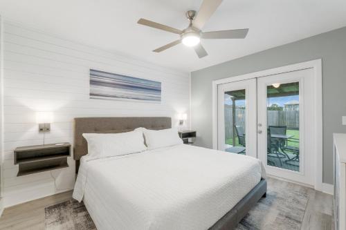 a white bedroom with a bed and a ceiling fan at Blue Neptune at 5313 Sunset Avenue by Nautical Properties Vacation Rentals in Panama City Beach