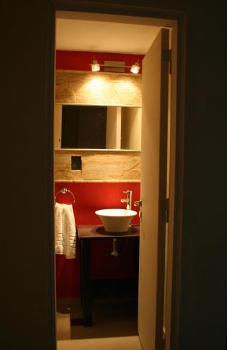 a bathroom with a sink and a red wall at Casa Alta Hotel Boutique & Spa - Solo Adultos in Villa Carlos Paz