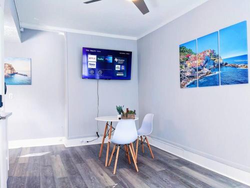 a dining room with a table and a tv on the wall at Elegant 1Bed Montrose-CinqueTerre@TheItalianPlaza in Houston