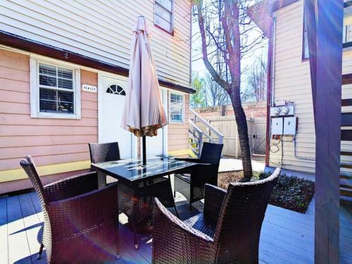 un tavolo e sedie con un ombrellone in un patio di Elegant 1Bed Montrose-CinqueTerre@TheItalianPlaza a Houston
