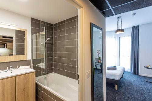 La salle de bains est pourvue d'une baignoire et d'un lavabo. dans l'établissement Nemea Appart Hotel Nice Arenas Aéroport, à Nice