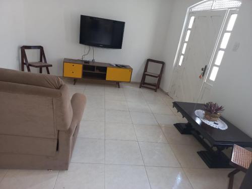 a living room with a couch and a tv at Casa para até 8 pessoas em Garanhuns in Garanhuns