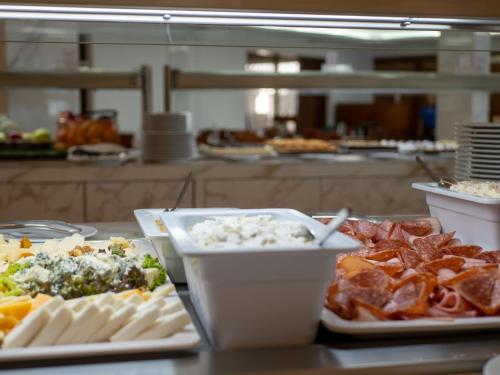 un buffet de comida en una mesa en una cocina en Ramada Loutraki Poseidon Resort, en Loutraki
