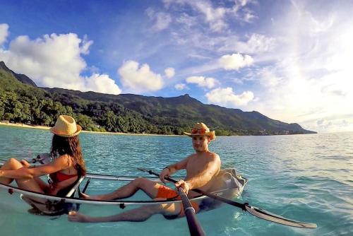 a man and a woman in a boat in the water at Les Jolies Eaux Villa - Chateau Elysium in Beau Vallon