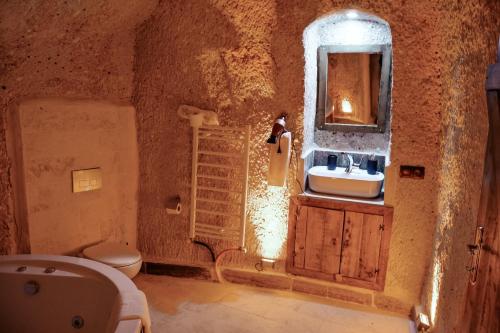uma casa de banho com um lavatório e um WC em MASAL CAVE SUITES OTEL em Ürgüp