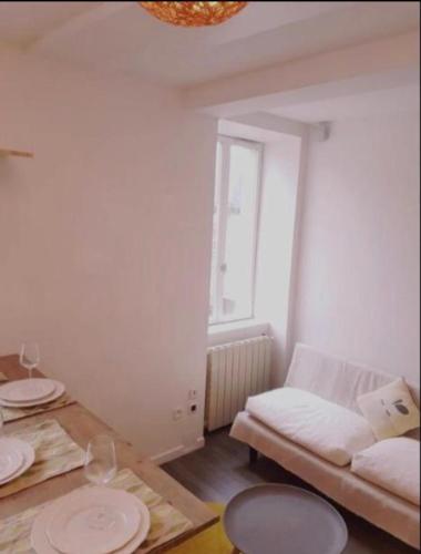 un salon avec une table et un canapé dans l'établissement Charmant Logement à Vierzon centre, à Vierzon