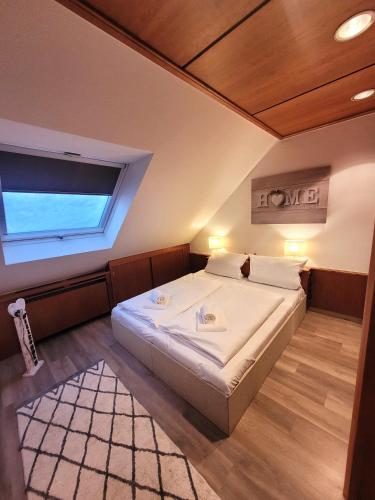 1 dormitorio con 1 cama grande y ventana en Winterberg Appartement 21077, en Winterberg