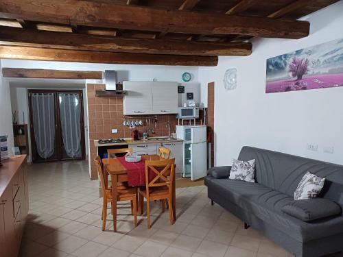 a kitchen and a living room with a couch and a table at Il Vicolo House in Santa Rufina