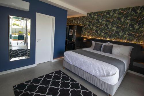 a bedroom with a large bed and a blue wall at The View - Adults Only Resort in Pipa