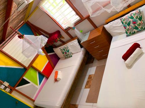 a small room with two beds in a house at Le Petit Paradis in Roseau