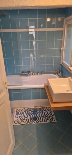 ein Badezimmer mit einer Badewanne, einem Waschbecken und einem Teppich in der Unterkunft Jolie Villa piscine vue mer in Tourrettes-sur-Loup