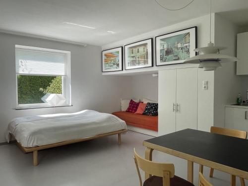 a bedroom with a bed and a table and a couch at Gartenstudio Peony in Innsbruck