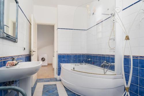 een badkamer met een wit bad en een wastafel bij Casa Parte e Sole in Posada
