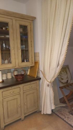a kitchen with a wooden cabinet and a curtain at AMELIE in Levidi