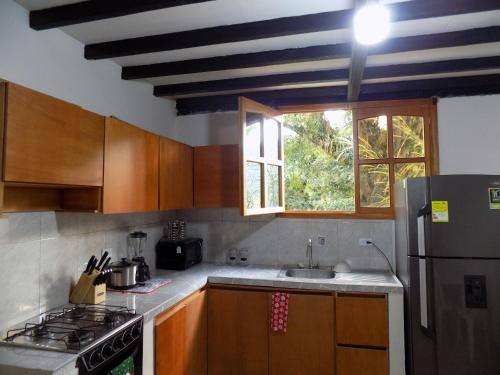 a kitchen with a stove and a sink and a window at Finca La Esperanza Pereira in Pereira