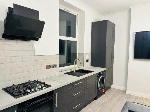 a kitchen with a sink and a stove top oven at Newly Refurbished 1Bedroom 4 mins walk to Crystal Palace Station in Crystal Palace