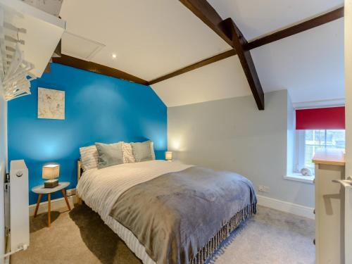 a bedroom with blue walls and a large bed at 2 bed property in Llandysul 77655 in Llangynllo