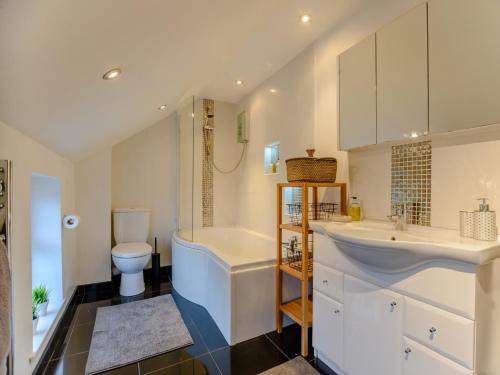 a bathroom with a sink and a tub and a toilet at 2 bed property in Llandysul 77655 in Llangynllo